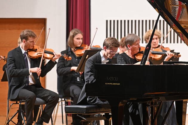 Konzert des Orchesters der Gesellschaft der Musikfreunde Gmunden, im Toskana Kongress, im Rahmen der Salzkammergut Festwochen in Gmunden, am 30.10.21. Das Bild zeigt den Pianisten Florian Feilmair im Spiel, mit ihn umgebenden Geigern 2021 - Konzert des Orchesters der Gesellschaft der Musikfreunde Gmunden, im Toskana Kongress, im Rahmen der Salzkammergut Festwochen in Gmunden, am 30.10.21