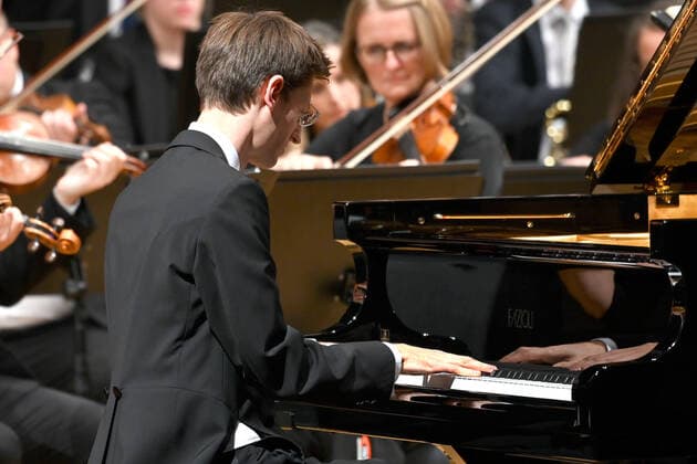 Konzert des Orchesters der Gesellschaft der Musikfreunde Gmunden, im Toskana Kongress, im Rahmen der Salzkammergut Festwochen in Gmunden, am 30.10.21. Das Bild zeigt den Pianisten Florian Feilmair im Spiel, mit ihn umgebenden Geigern 2021 - Konzert des Orchesters der Gesellschaft der Musikfreunde Gmunden, im Toskana Kongress, im Rahmen der Salzkammergut Festwochen in Gmunden, am 30.10.21
