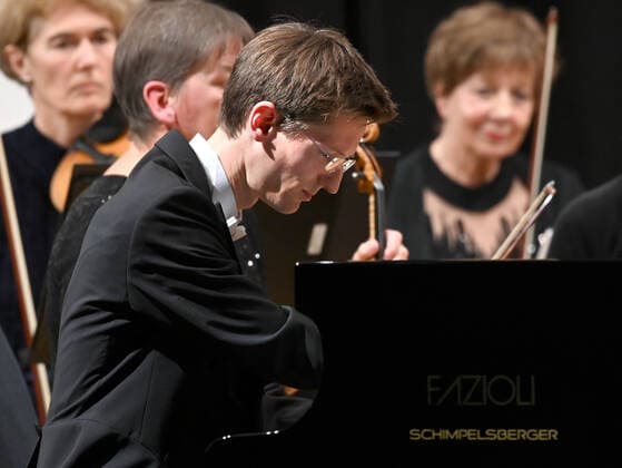 Konzert des Orchesters der Gesellschaft der Musikfreunde Gmunden, im Toskana Kongress, im Rahmen der Salzkammergut Festwochen in Gmunden, am 30.10.21. Das Bild zeigt den Pianisten Florian Feilmair im Spiel, mit ihn umgebenden MusikerInnen 2021 - Konzert des Orchesters der Gesellschaft der Musikfreunde Gmunden, im Toskana Kongress, im Rahmen der Salzkammergut Festwochen in Gmunden, am 30.10.21