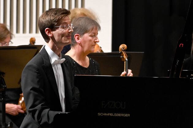 Konzert des Orchesters der Gesellschaft der Musikfreunde Gmunden, im Toskana Kongress, im Rahmen der Salzkammergut Festwochen in Gmunden, am 30.10.21. Das Bild zeigt den Pianisten Florian Feilmair im Spiel, mit ihn umgebenden MusikerInnen 2021 - Konzert des Orchesters der Gesellschaft der Musikfreunde Gmunden, im Toskana Kongress, im Rahmen der Salzkammergut Festwochen in Gmunden, am 30.10.21