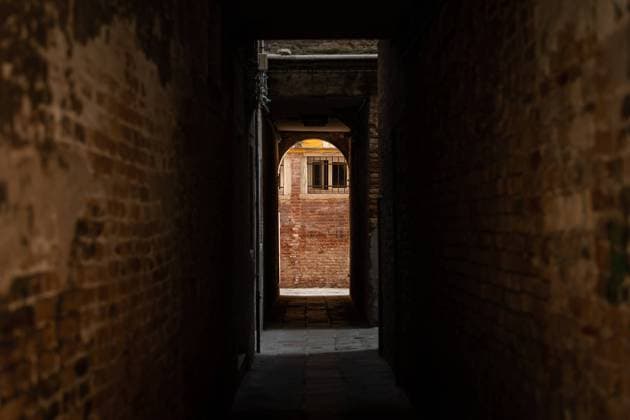 Dark narrow street in Venice (Italy) brick walls on the side Venice Italy