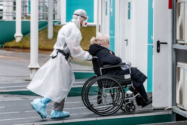MOSCOW, RUSSIA â€“ NOVEMBER 5, 2021: A healthcare worker takes a patient to the admission ward at the Novomoskovsky multipurpose medical centre treating patients who suffer from the novel coronavirus disease (COVID-19). Sergei Karpukhin TASS  TS116DBB