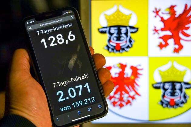 Coronavirus in Deutschland - Covid-19-Dashboard des Robert Koch-Institut DEU, Deutschland, Mecklenburg-Vorpommern 07.11.2021: Die 7-Tage-Inzidenz für das Bundesland (Fälle letzte 7 Tage 100.000 EW) wird auf einem iPhone angezeigt, im Hintergrund das Landeswappen