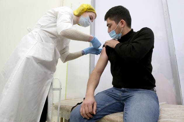 ST PETERSBURG, RUSSIA - NOVEMBER 8, 2021: A medical worker gives an injection to a patient at a COVID-19 vaccination site at the Zanevsky Kaskad shopping mall. Alexander Demianchuk TASS  TS11713C