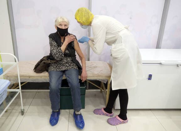 ST PETERSBURG, RUSSIA - NOVEMBER 8, 2021: A medical worker gives an injection to a patient at a COVID-19 vaccination site at the Zanevsky Kaskad shopping mall. Alexander Demianchuk TASS  TS11713E