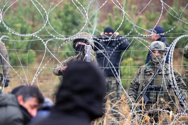 BELARUS - NOVEMBER 8, 2021: Polish police officers guard the area by the Belarusian-Polish border. Nearly 1,000 refugees were heading towards the Polish border in the morning of November 8, 2021. The foreigners intend to exercise their right to apply for a refugee status in an EU country. Poland s troops in the border regions were put on full alert. Leonid Shcheglov BelTA TASS  TS11727A