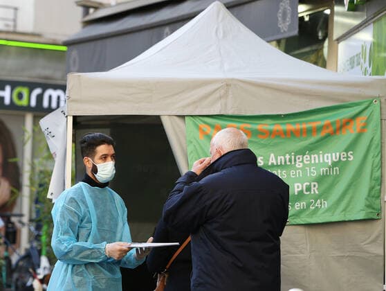 (211110) -- PARIS, Nov. 10, 2021 -- A resident talks with a medical staff in front of a fast COVID-19 test screening tent in Paris, France, Nov. 9, 2021. French President Emmanuel Macron announced Tuesday evening to postpone the pre-decided easing of anti-COVID-19 measures, since France is undergoing the fifth wave of the pandemic. People over 65 years old and the most vulnerable ones will have to get a booster dose in order to validate their health pass from Dec. 15. ) FRANCE-PARIS-COVID-19-BOOSTER SHOT GaoxJing 