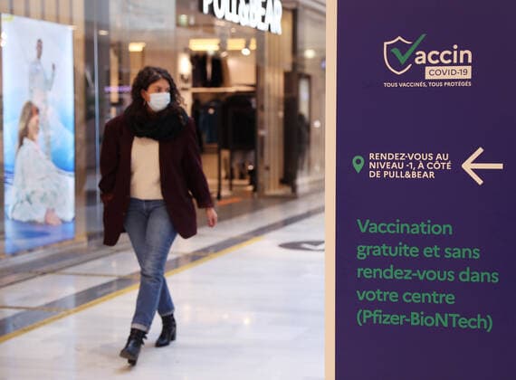 (211110) -- PARIS, Nov. 10, 2021 -- A customer walks past a sign indicating a COVID-19 vaccination center inside a shopping mall in Levallois-Perret near Paris, France, Nov. 9, 2021. French President Emmanuel Macron announced Tuesday evening to postpone the pre-decided easing of anti-COVID-19 measures, since France is undergoing the fifth wave of the pandemic. People over 65 years old and the most vulnerable ones will have to get a booster dose in order to validate their health pass from Dec. 15. ) FRANCE-PARIS-COVID-19-BOOSTER SHOT GaoxJing 
