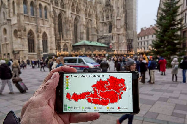 - Wien 12.11.2021 - Coronavirus Krise - Kurz vor Beginn der Wintersaison stuft Deutschland Österreich seit heute wieder als Hochrisikogebiet ein. Das teilte Deutschlands Gesundheitsminister Jens Spahn (CDU) heute mit. Personen, die weder geimpft noch genesen sind, müssen nach einem Aufenthalt in Österreich nach der Einreise in Deutschland in zehntägige Quarantäne. Die stark steigenden Infektionszahlen in Österreich sind mit ein Grund für die Reisewarnung. Der Bundeskanzler wird am Sonntag einen bundesweiten Lockdown für Ungeimpfte verkünden. PHOTO: Die Corona-Ampel steht auf Rot für ganz Österreich, regionale Lockdowns stehen bevor. In der Wiener Innenstadt herrscht trotzdem reges Treiben wie hier auf dem Weihnachtsmarkt vor dem Stephans 