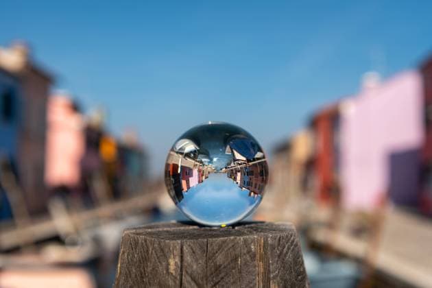IMAGO Creative: Dichotomien, Reflexionen - Architektur IMAGO Creative: Dichotomien, Reflexionen Glass ball lying on pillar in front of colorful houses in Burano, Venice (Italy), sunny day in late autumn Venice Italy