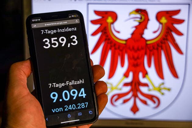 Coronavirus in Deutschland - Covid-19-Dashboard des Robert Koch-Institut DEU, Deutschland, Brandenburg 14.11.2021: Die 7-Tage-Inzidenz für das Bundesland (Fälle letzte 7 Tage 100.000 EW) wird auf einem iPhone angezeigt, im Hintergrund das Landeswappen