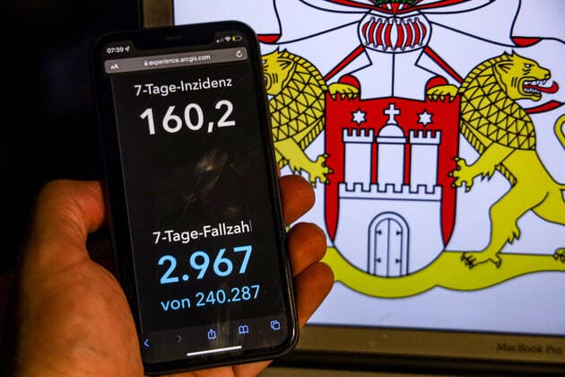 Coronavirus in Deutschland - Covid-19-Dashboard des Robert Koch-Institut DEU, Deutschland, Hamburg 14.11.2021: Die 7-Tage-Inzidenz für das Bundesland (Fälle letzte 7 Tage 100.000 EW) wird auf einem iPhone angezeigt, im Hintergrund das Landeswappen