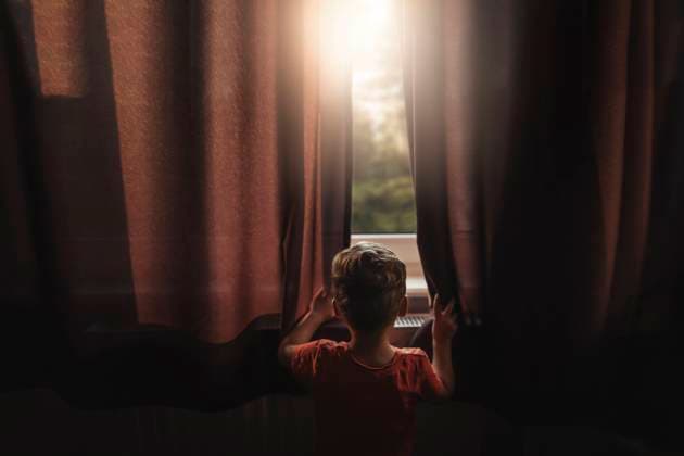 IMAGO Creative: Gesellschaft, Armut IMAGO Creative: Jahreszeit Winter, Fantasievoll drinnen spielen Back view of boy peaking outside through windows Szczecin, West Pomeranian Voivodeship, Poland CR_XCKH21111565-860684-01 ,model released, Symbolfoto