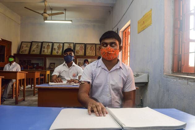 November 16, 2021, Kolkata, India: A visually impaired student reads a braille book while wearing a face mask in his class at a blind school in Kolkata..After being closed for almost 20 months due to the Covid-19 pandemic, the schools in West Bengal resumes the operation. Kolkata India - ZUMAs197 20211116_zaa_s197_003 Copyright: xSumitxSanyalx