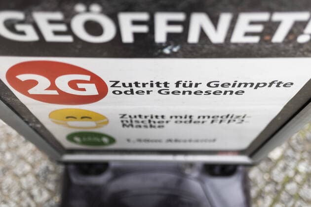 Ein Hinweis zum Einlass mit der 2G-Regel (Genesen oder Geimpft) zeichnet auf einem Plakat ab in Berlin, 17.11.2021. Berlin Deutschland *** A notice to enter with the 2G rule Convalescent or Vaccinated signs off on a poster in Berlin, 17 11 2021 Berlin Germany Copyright: xFlorianxGaertner photothek.dex