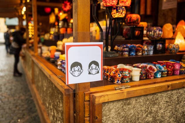 Hinweisschild zur Maskenpflicht an einem Verkaufsstand - Eröffnungstag des Weihnachtsmarktes 2021 auf dem Münsterplatz in Bonn. Aufgrund den stark angestiegenen Infektionen am Corona Virus darf der Markt nur von Menschen besucht werden, die die 2G Regel (geimpft oder genesen) erfüllen. 17.10.2021 Bonn Innenstadt NRW Deutschland