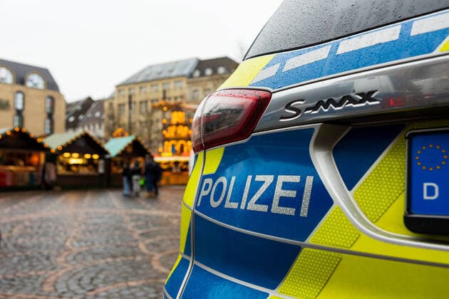 Ein Polizeiwagen auf dem Marktgelände. Die Polzei zeigt eine spürbare Präsenz um auf dem Weihnachtsmarkt für Sicherheit zu sorgen. Eröffnungstag des Weihnachtsmarktes 2021 auf dem Münsterplatz in Bonn. Aufgrund den stark angestiegenen Infektionen am Corona Virus darf der Markt nur von Menschen besucht werden, die die 2G Regel (geimpft oder genesen) erfüllen. 17.10.2021 Bonn Innenstadt NRW Deutschland
