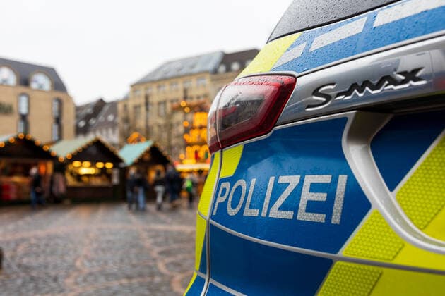 Ein Polizeiwagen auf dem Marktgelände. Die Polzei zeigt eine spürbare Präsenz um auf dem Weihnachtsmarkt für Sicherheit zu sorgen. Eröffnungstag des Weihnachtsmarktes 2021 auf dem Münsterplatz in Bonn. Aufgrund den stark angestiegenen Infektionen am Corona Virus darf der Markt nur von Menschen besucht werden, die die 2G Regel (geimpft oder genesen) erfüllen. 17.10.2021 Bonn Innenstadt NRW Deutschland