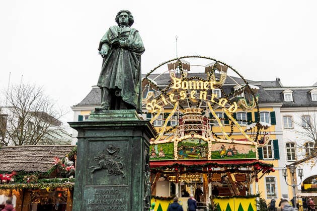 Das Beethoven Denkmal vor dem Bonner Riesenrad inmitten des Weihnachtsmarktes - Eröffnungstag des Weihnachtsmarktes 2021 auf dem Münsterplatz in Bonn. Aufgrund den stark angestiegenen Infektionen am Corona Virus darf der Markt nur von Menschen besucht werden, die die 2G Regel (geimpft oder genesen) erfüllen. 17.10.2021 Bonn Innenstadt NRW Deutschland