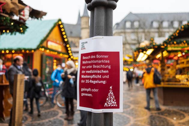 Hinweisschild der Stadt Bonn mit der Aufschrift: Besuch des Weihnachtsmarktes nur unter Beachtung der medizinischen Maskenpflicht und der 2G-Regelung: geimpft oder genesen - Eröffnungstag des Weihnachtsmarktes 2021 auf dem Münsterplatz in Bonn. 17.10.2021 Bonn Innenstadt NRW Deutschland