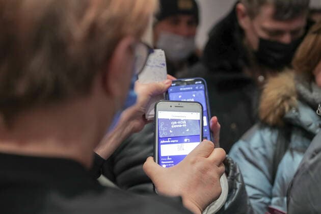 Coronavirus in Russland, Kontrolle des Impfstatuses bei Theaterbesuchern in Kemerewo KEMEROVO, RUSSIA - NOVEMBER 17, 2021: People have their QR codes checked at an entrance to Shtokolov Kemerovo State Philharmonic ahead of a concert by the Mariinsky Theatre Symphony Orchestra. People have to present QR codes, vaccination certificates, negative PCR tests or certificates of medical exemption from COVID-19 vaccines while visiting cafes, beauty salons, culture and sports facilities in Russia s Kemerovo Region due to the rise of COVID-19 cases. Danil Aikin TASS  TS1183E3