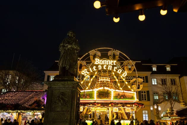 Das Denkmal von Ludwig van Beethoven vor dem Bonner Riesenrad inmitten des Marktes - Weihnachtsmarkt auf dem Münsterplatz in Bonn an seinem Eröffnungstag, 17.11.2021 Bonn Innenstadt NRW Deutschland