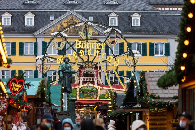 Das Denkmal von Ludwig van Beethoven vor dem Bonner Riesenrad auf dem Münsterplatz - Der Bonner Weihnachtsmarkt im Schatten der Corona Pandemie. Auf dem Marktgelände gilt die 2G Regel (geimpft oder genesen) zudem herrscht im Innenstadtbereich die Maskenpflicht 19.11.2021 Bonn Innenstadt NRW Deutschland