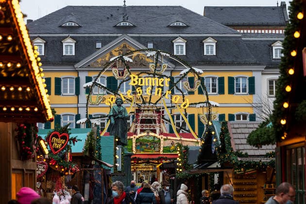 Das Denkmal von Ludwig van Beethoven vor dem Bonner Riesenrad auf dem Münsterplatz - Der Bonner Weihnachtsmarkt im Schatten der Corona Pandemie. Auf dem Marktgelände gilt die 2G Regel (geimpft oder genesen) zudem herrscht im Innenstadtbereich die Maskenpflicht 19.11.2021 Bonn Innenstadt NRW Deutschland