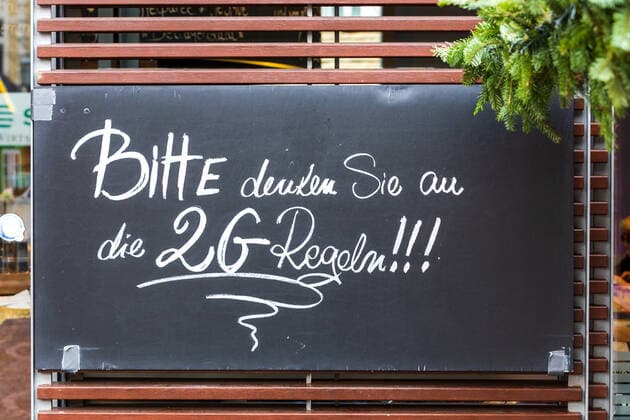 Ein Schild mit der Aufschrift Bitte denken Sie an die 2G Regeln - Der Bonner Weihnachtsmarkt im Schatten der Corona Pandemie. Auf dem Marktgelände gilt die 2G Regel (geimpft oder genesen) zudem herrscht im Innenstadtbereich die Maskenpflicht 19.11.2021 Bonn Innenstadt NRW Deutschland