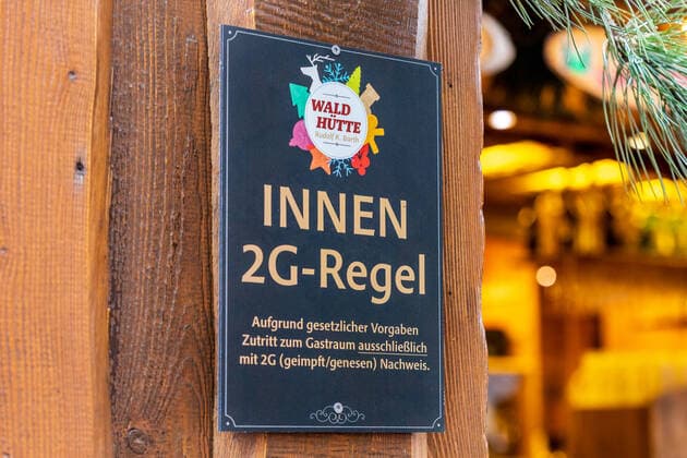 Ein Hinweisschild mit der Aufschrift Innen 2G Regel Der Bonner Weihnachtsmarkt im Schatten der Corona Pandemie. Auf dem Marktgelände gilt die 2G Regel (geimpft oder genesen) zudem herrscht im Innenstadtbereich die Maskenpflicht 19.11.2021 Bonn Innenstadt NRW Deutschland