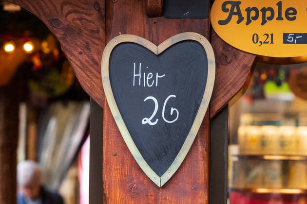 Ein Schild mit der Aufschrift HIer 2G an einem Glühweinstand - Der Bonner Weihnachtsmarkt im Schatten der Corona Pandemie. Auf dem Marktgelände gilt die 2G Regel (geimpft oder genesen) zudem herrscht im Innenstadtbereich die Maskenpflicht 19.11.2021 Bonn Innenstadt NRW Deutschland