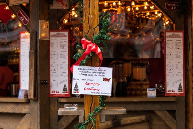 Ein Hinweisschild mit der Aufschrift Bitte beachten Sie dass der Weihnachtsmarkt unter der 2G Regelung stattfindet. Daher dürfen wir nur Geimpfte oder Genesene Personen bedienen. - Der Bonner Weihnachtsmarkt im Schatten der Corona Pandemie. Auf dem Marktgelände gilt die 2G Regel (geimpft oder genesen) zudem herrscht im Innenstadtbereich die Maskenpflicht 19.11.2021 Bonn Innenstadt NRW Deutschland