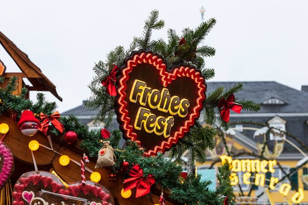 Ein weihnachtlich geschmücktes Schild mit der Aufschrift Frohes Fest - Der Bonner Weihnachtsmarkt im Schatten der Corona Pandemie. Auf dem Marktgelände gilt die 2G Regel (geimpft oder genesen) zudem herrscht im Innenstadtbereich die Maskenpflicht 19.11.2021 Bonn Innenstadt NRW Deutschland