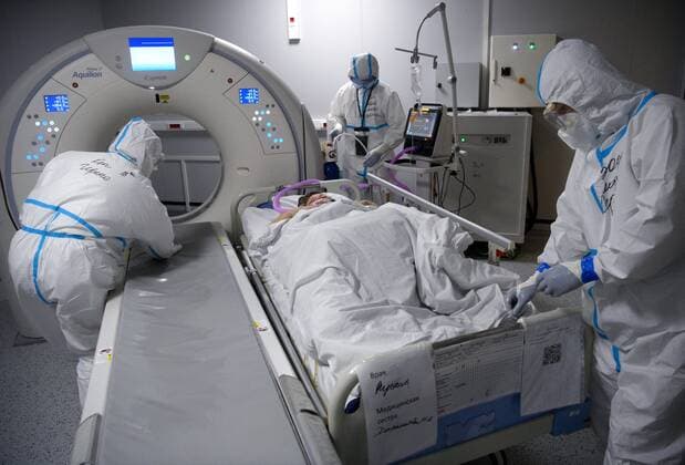 Russia Coronavirus Treatment 6700055 19.11.2021 Medical specialists wearing protective gear prepare a patient for a CT scan at a pavilion of the Exhibition of Achievements of National Economy (VDNH), which was converted into a reserve hospital for people suffering from the coronavirus disease, in Moscow, Russia. Ilya Pitalev Sputnik Moscow Russia  Copyright: xIlyaxPitalevx