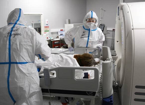 Russia Coronavirus Treatment 6700074 19.11.2021 Medical specialists wearing protective gear prepare a patient for a CT scan at a pavilion of the Exhibition of Achievements of National Economy (VDNH), which was converted into a reserve hospital for people suffering from the coronavirus disease, in Moscow, Russia. Ilya Pitalev Sputnik Moscow Russia  Copyright: xIlyaxPitalevx