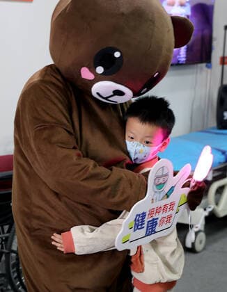 (211120) -- SHANGHAI, Nov. 20, 2021 -- A staff member in cartoon costume comforts a boy at a vaccination site in Xuhui District of Shanghai, east China, Nov. 20, 2021. Shanghai started COVID-19 vaccination for children aged 3-5 from Saturday. ) CHINA-SHANGHAI-COVID-19-CHILDREN-VACCINATION (CN) LiuxYing 