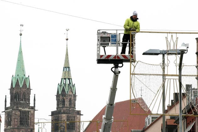 Arbeiter montiert die Weihnachtsbeleuchtung . Aufgrund der neuen Beschränkungen für das Coronavirus ist der Christkindlesmarkt 2021 abgesagt. Die Verkäufer bauen die Stände ab. during the Light Lockdown of the Covid 19 Coronavirus Pandemie in Nürnberg , Bayern, Deutschland . November 20, 2021.