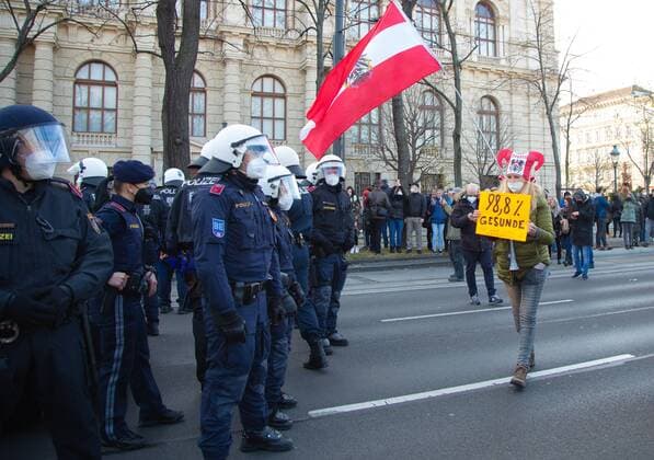 Austria Coronavirus Restrictions Protest 6700649 20.11.2021 A woman holding a placard stands in front of police officers during a rally against COVID-19 lockdown and mandatory vaccination, in Vienna, Austria. Thousands of protesters have gathered in Austria?s capital after the government announced a nationwide lockdown to contain the quickly rising coronavirus infections and said vaccines would be made compulsory starting February 1. Stringer Sputnik Vienna Austria  Copyright: xStringerx