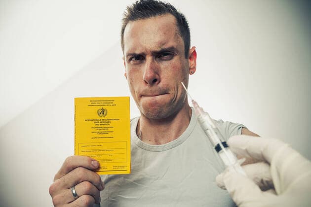 22 November 2021: Covid 19 vaccination, man with a yellow vaccination card, vaccination book in hand is afraid of the syringe with the vaccine dose *** Covid 19 Impfung, Mann mit einem gelben Impfpass, Impfbuch in der Hand hat angst vor der Spritze mit der Impfdosis