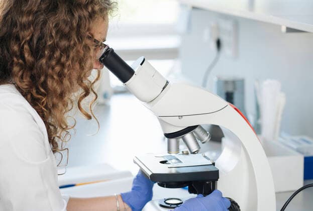 Scientist researching on sample through microscope in laboratory model released property released, AHSF02831
