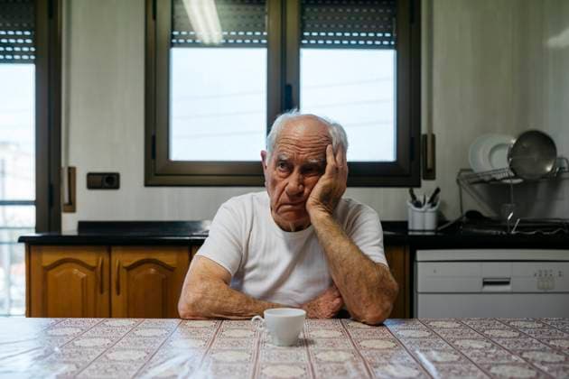 Sad man sitting at table in kitchen model released property released, JRFF05189