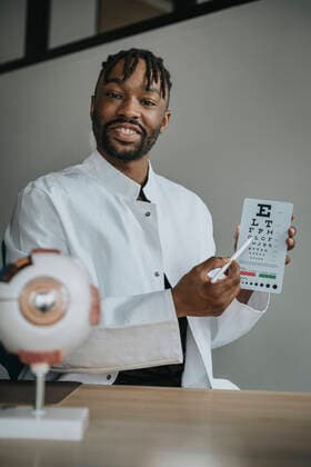 Young ophthalmologist holding alphabet chart at desk model released property released, MFF08318