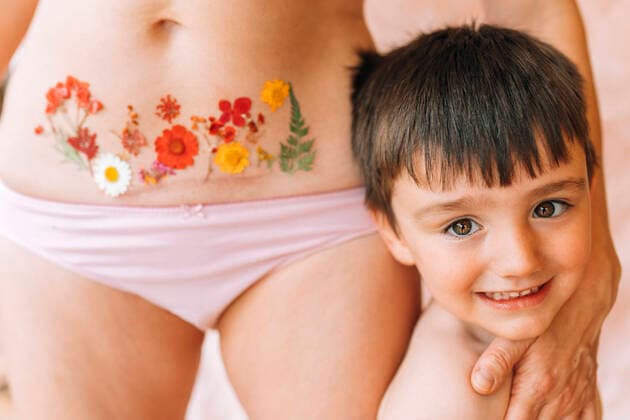 Creative Highlights Symbolbilder Smiling son by mother with flowers tattoo on Ceasarean scar model released, EGHF00256