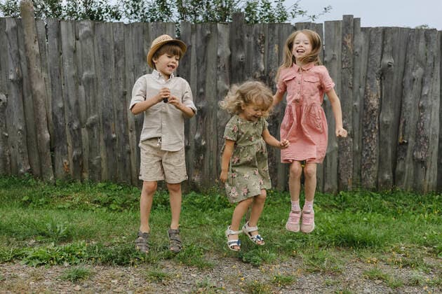 Playful siblings jumping in front of wooden fence model released, SEAF00043