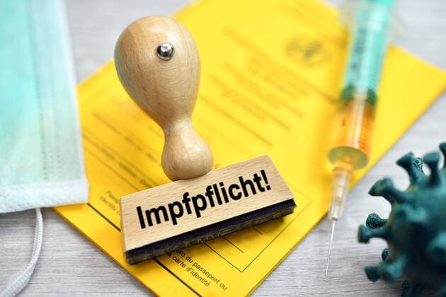 FOTOMONTAGE, Stempel auf Impfpass mit Aufschrift Impfpflicht