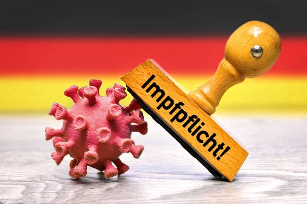 FOTOMONTAGE, Stempel auf Coronavirus-Modell mit Aufschrift Impfpflicht