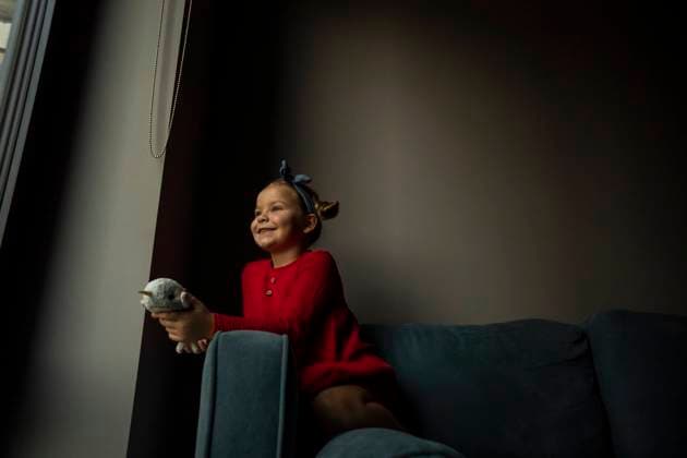 IMAGO Creative: 2021 Favoriten IMAGO Creative: Jahreszeit Winter, Couching IMAGO Creative: Jahreszeit Winter, Fantasievoll drinnen spielen Happy girl holding toy on sofa model released property released, SSGF00221