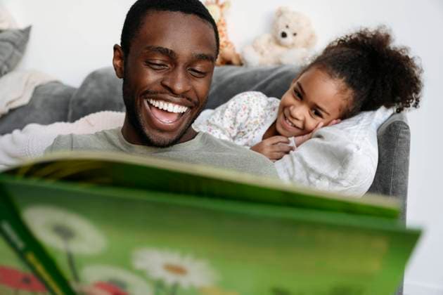 Father laughing while telling story to daughter at home model released property released, VYF00603