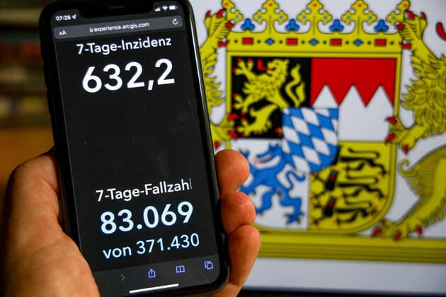 Coronavirus in Deutschland - Covid-19-Dashboard des Robert Koch-Institut DEU, Deutschland, Bayern 28.11.2021: Die 7-Tage-Inzidenz für das Bundesland (Fälle letzte 7 Tage 100.000 EW) wird auf einem iPhone angezeigt, im Hintergrund das Landeswappen