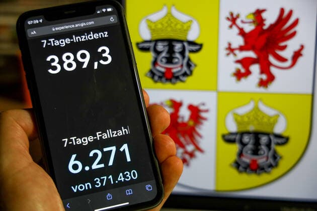 Coronavirus in Deutschland - Covid-19-Dashboard des Robert Koch-Institut DEU, Deutschland, Mecklenburg-Vorpommern 28.11.2021: Die 7-Tage-Inzidenz für das Bundesland (Fälle letzte 7 Tage 100.000 EW) wird auf einem iPhone angezeigt, im Hintergrund das Landeswappen